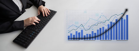 A business professional engages with a keyboard while analyzing a financial growth chart, showcasing...