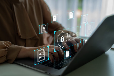 Woman Typing on Laptop with Digital Security Icons Representing Data Protection and Cybersecurity...