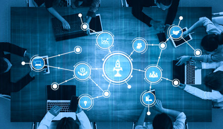 A diverse group of professionals engaged in a business meeting, utilizing digital tools to...