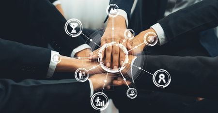A group of business professionals uniting hands in a circle, symbolizing teamwork and collaboration,...
