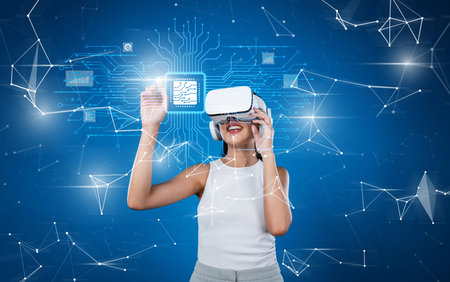A joyful woman wearing a virtual reality headset interacts with digital tech elements, showcasing...