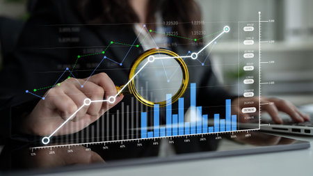 A business professional uses a magnifying glass to examine financial data on a modern digital...