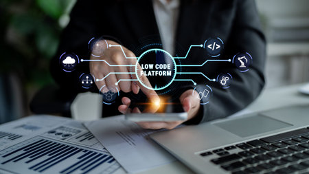 Business person using smartphone with digital graphics representing low code platform technology for...