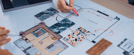 Engaging scene of hands collaborating on an architectural floor plan. Colorful swatches and detailed...