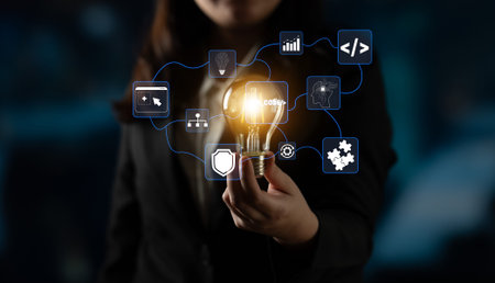 Business Professional Holding Light Bulb with Digital Icons Representing Innovation, Technology, and...
