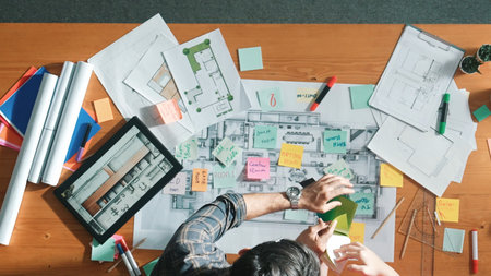 Top view of engineer working together to design building construction while standing at meeting...