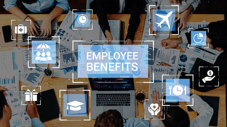 Collaborative Office Workspace with Graphics Illustrating Employee Benefits and Professional Team Engaged in Discussion Over Work Materials.の写真素材