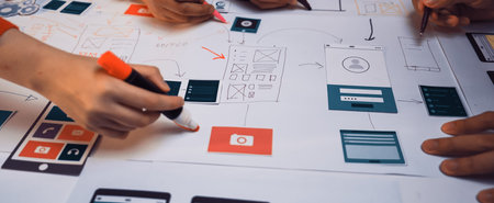 A group of creative individuals engaged in a productive design session for user interface layouts,...