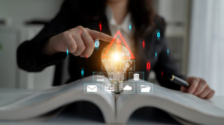 Businesswoman Using Digital Light Bulb Graphics on Open Book to Symbolize Innovative Ideas and...