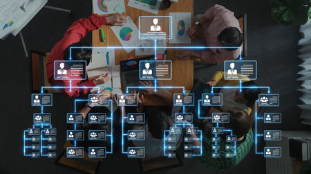 Aerial view of a diverse team collaborating around a table, utilizing an organizational chart and...
