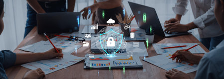 Team Collaboration in Modern Office Featuring Digital Security Concept with Charts, Laptops, and...