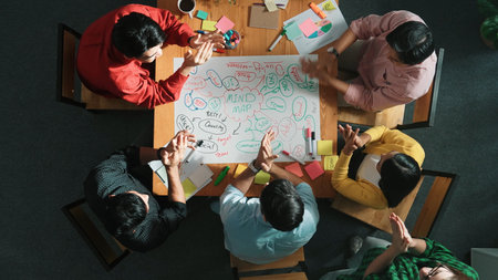 Top down view of business team working together by using mind map brainstorming idea while putting...