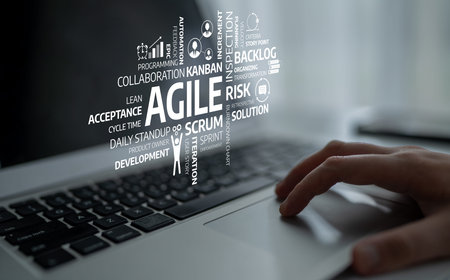 A close-up shot of a laptop keyboard featuring Agile methodology concepts represented through words. This image is ideal for showcasing software development and project management themes. Tesselの写真素材