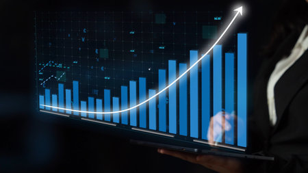 A business professional examines growth trends on a laptop screen displaying an upward graph,...