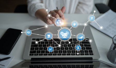 This image showcases a hand interacting with digital icons on a laptop, representing the concept of...