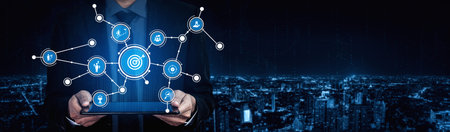 A business professional interacts with digital icons representing networking and technology, set...