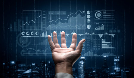 A human hand reaches toward a glowing digital display of data analytics, featuring various graphs...
