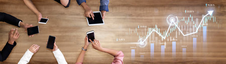 A collection of diverse hands interacting with smartphones and tablets on a wooden table, focusing...