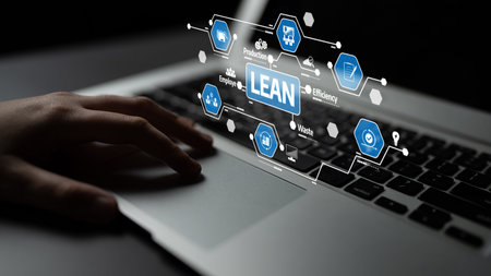 A close-up of a hand resting on a laptop keyboard with visual representations of lean methodology...