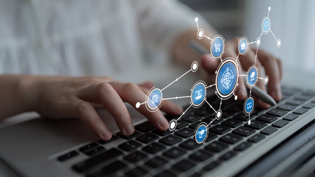A close-up view of hands typing on a laptop keyboard surrounded by digital icons representing...