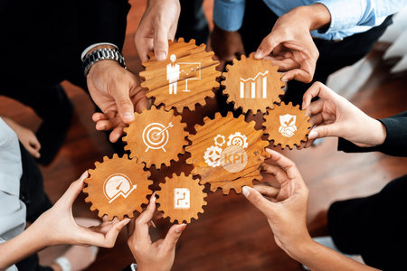 A group of diverse hands holds wooden gears symbolizing collaboration and business objectives, with...