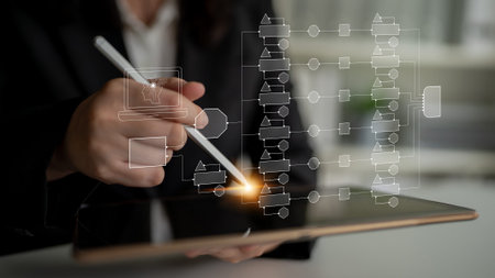 Professional businesswoman using digital tablet to create flowchart with stylus pen in modern office...