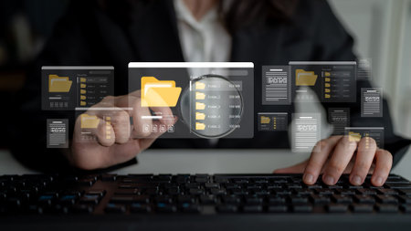 A professional individual interacts with a computer, visually exploring folders and files in a dynamic digital workspace, highlighting efficiency and modern technology. Ledgerの写真素材