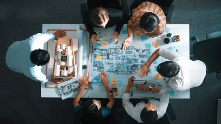Top aerial view of project manager or civil engineer writing at blueprint and planning building...