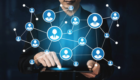 A business professional interacts with a digital tablet displaying a network of social media icons,...