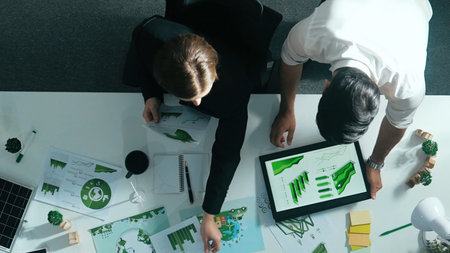 Top down view of business man presenting sustainable idea to manager by using tablet display ESG environmental social governance. Manager working together planning to use clean energy. Alimentation.の写真素材