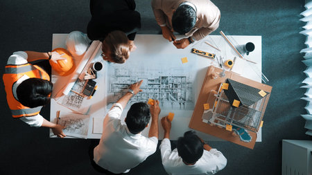 Top down view of skilled engineer team talking about house construction. Aerial view of group of...