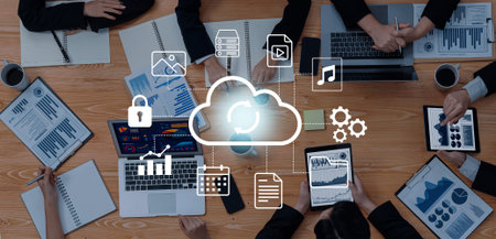 A dynamic view of a team collaborating in a modern workspace, showcasing laptops, tablets, and cloud...