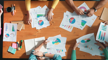 Top down view of start up business team holding paper while discussing about financial idea. Aerial...