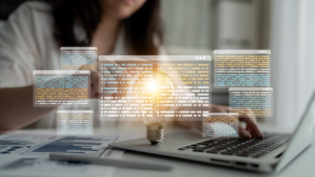 A creative workspace scene featuring a glowing light bulb surrounded by data code overlays,...