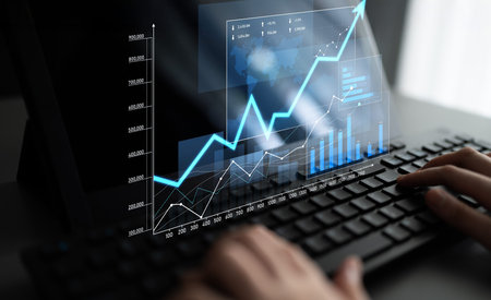 A close-up view of hands typing on a keyboard while displaying various digital graphs and analytics,...