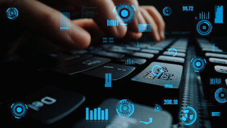 Hands are typing on a computer keyboard illuminated by digital overlays, showcasing data analysis...
