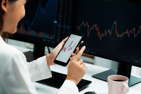 Cropped image in businesswoman using smartphone in profitable of exchange stock market graph...