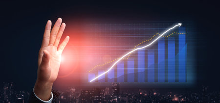 A professional hand represents business growth, showcasing a digital graph with upward trends in a modern urban setting, ideal for finance and success visuals. Impute