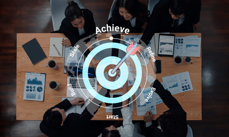 A top-down view of a team collaborating in an office setting, focusing on goal setting and strategic planning with visual targets overlaid, symbolizing achievement and growth. Gantry