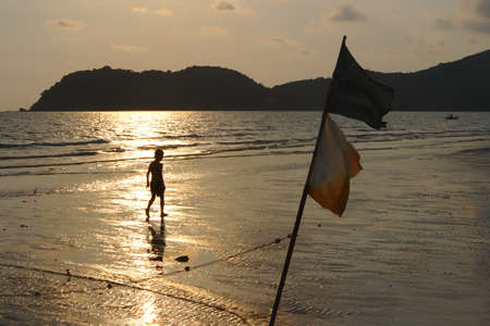 Shadow of a child walking on the beach in the evening.の写真素材