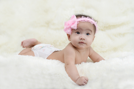 asian cute baby sitting on a soft cloth in the living room.の写真素材