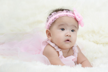 Baby sitting on a soft cloth in the living roomの写真素材