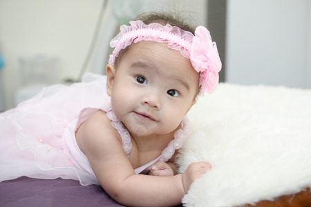 Baby sitting on a soft cloth in the living roomの写真素材