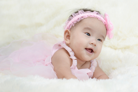 Baby sitting on a soft cloth in the living roomの写真素材