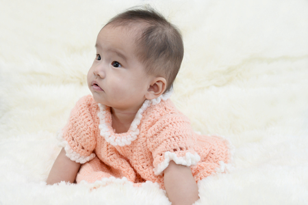 Baby sitting on a soft cloth in the living roomの写真素材