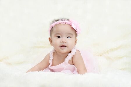 Baby sitting on a soft cloth in the living roomの写真素材