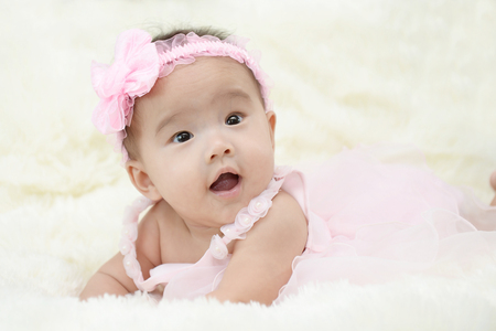 Baby sitting on a soft cloth in the living roomの写真素材