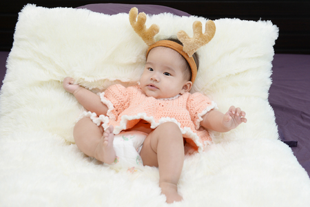 Baby sitting on a soft cloth in the living roomの写真素材