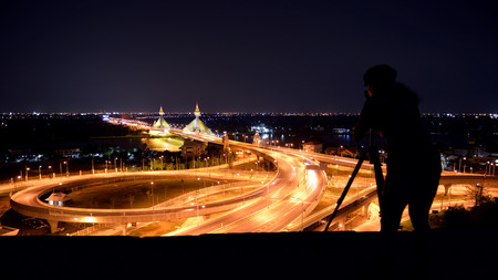 Silhouette of a photographer with the beautiful lights of the bridge.