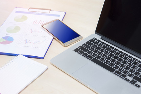 Photo on the desk with a phone and computer.の写真素材